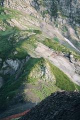 Part of the mountain is beautifully lit. Rocky mountain with a small grass cover.