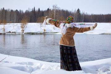 Beautiful young woman in a winter landscape with river and snow. Sunny frosty day