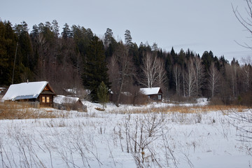 Rural landscape of Russia. Winter village with a house and forest