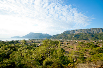Fototapeta na wymiar Scenic view of the mountains, sea and forest taken on a bright sunny day
