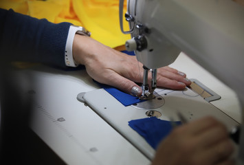 A woman working with a sewing machine. No face shown