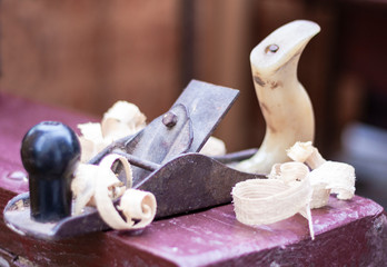 Joinery – old wooden plane and chips in a workshop of the carpenter