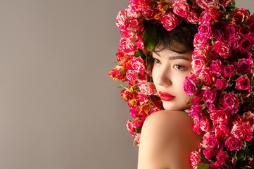 curly beautiful asian girl with bright makeup and roses on head