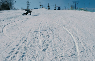 Teenage boy of 12 years sliding on a snowboard from snow descent next sky lift.