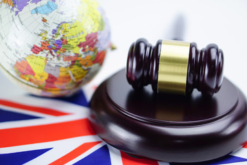 Obraz na płótnie Canvas United Kingdom of Great Britain and Northern Ireland flag and Judge hammer with globe world map. Law and justice court concept.