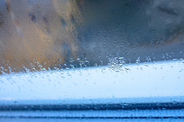 Water drops on blue glass, background photo of increased condensation, horizontal view, high quality