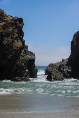 Big stone with gap at ocean beach California.