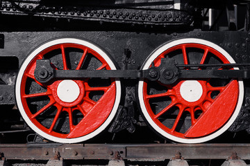 Old black, white and red locomotive is standing on the rails in a railway museum against a blue sky. Concept of history, the carriage of passengers, transport