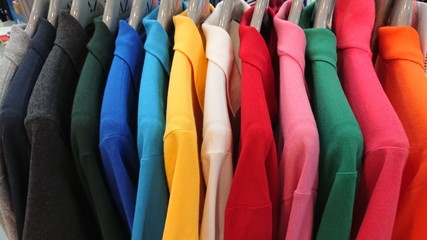 Colorful t-shirts on hangers
