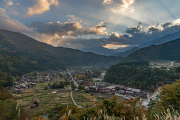 Top view point of shirakawago village in autumn with dramatic ray of light and colorful of clouds during sunset