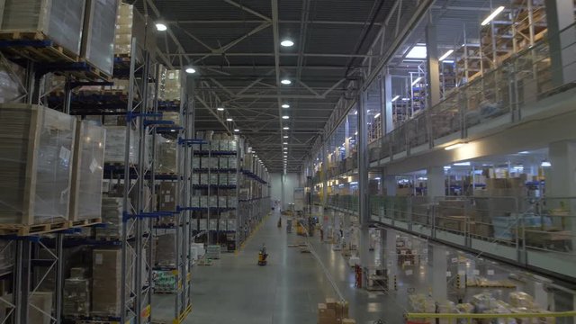 Huge warehouse and forklifts, racks with goods