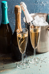 Champagne bottle in bucket with ice and glasses of champagne