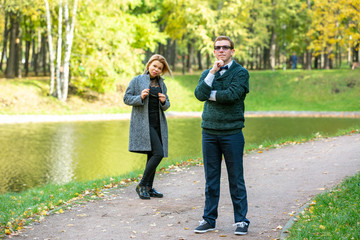 Couple talking seriously outdoors in a park with a green background
