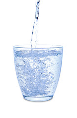 Pouring of mineral water in glass on white background