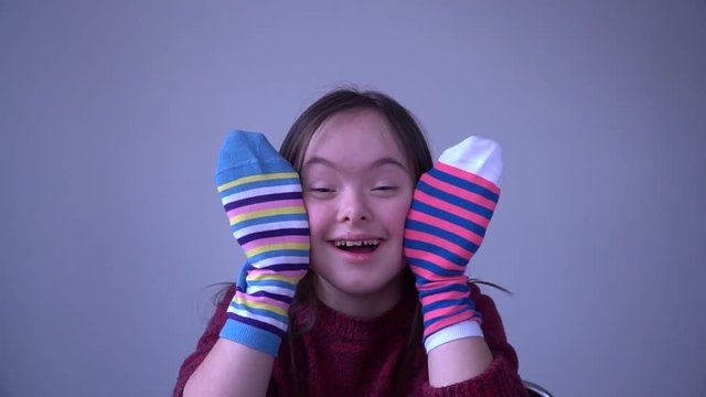 Girl with Down Syndrome have fun with different socks