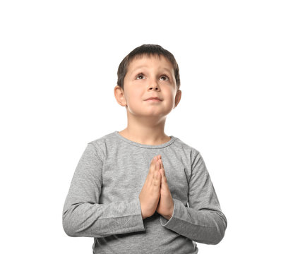 Little boy praying on white background