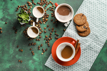 Many cups with tasty aromatic coffee and cookies on color table