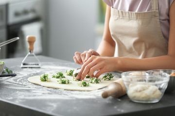 Woman making tasty vegetable ravioli on table