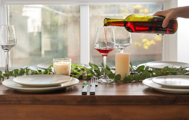 Woman pouring wine into glass on table in restaurant