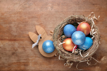 Nest with Easter eggs on wooden background