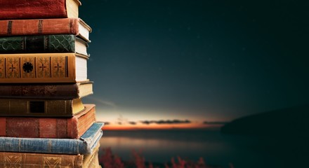 Ancient books in a row on wooden background