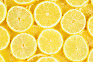 A slices of fresh juicy yellow lemons.  Texture background, pattern.