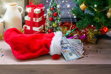 Obraz na płótnie Canvas Dollar banknotes in Santa sock and Christmas decoration background