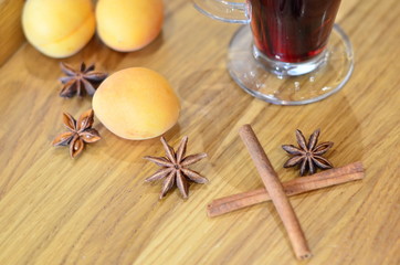 Mulled red, with fruit, cinnamon on a wooden background, winter drink