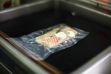 piece of fish in the vacuumizer. sterlet with butter and herbs - 231009847