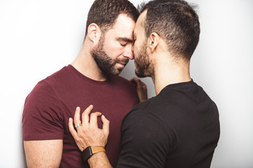 Young homosexuals gay couple love each other on a white background. - obrazy, fototapety, plakaty
