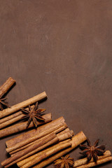 Cinnamon sticks with star anise on brown background. The view from the top. Place for recipe text
