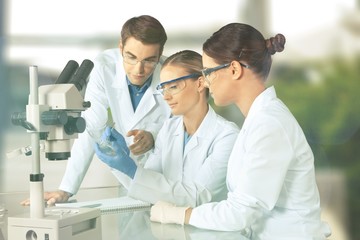 Female and male scientists in glasses working with microscope