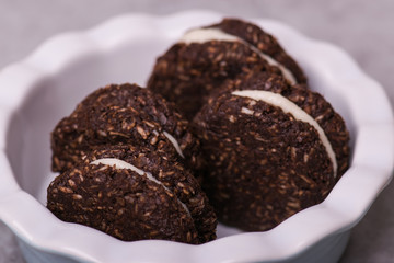 Chocolate biscuit with white cream on a white background.
