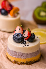 Multicolored cakes on the table with kiwi, lemon. Cakes with exotic fruits.