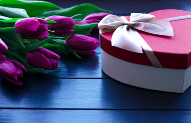Bouquet of tulips on blue wooden table with gift box. Happy women's day. 8 March. Valentines day.