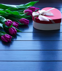 Bouquet of tulips on blue wooden table with gift box. Happy women's day. 8 March. Valentines day.