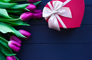 Bouquet of tulips on blue wooden table with gift box. Happy women's day. 8 March. Valentines day.