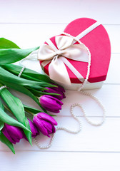 Bouquet of tulips on blue wooden table with gift box. Happy women's day. 8 March. Valentines day.