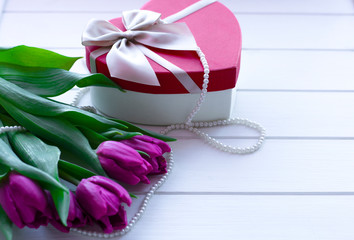 bouquet of tulips on wooden background. Womens day. Background with tulips and gift box