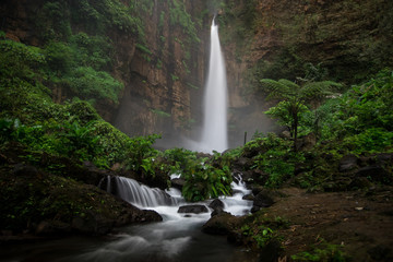 Dark and moody long exposure of the Kapas Biru waterfall in East Java, Indonesia