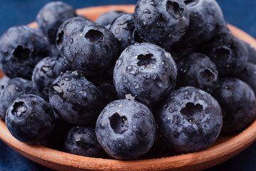 bog whortleberry in a clay cup on a blue background