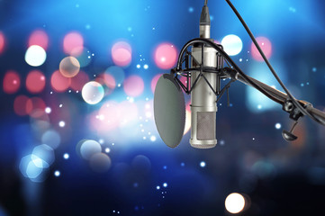 Condencer microphone with pop filter on stage ..Close up of microphone setting on stand with...