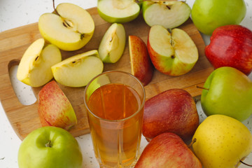  Apple juice in a glass and apples on the table.