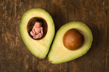 Baby sleeping in open avocado - Powered by Adobe