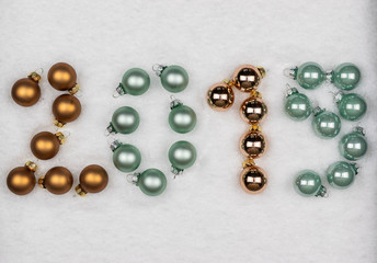 New year decoration concept: Christmas balls placed in year 2019 on a snowy background