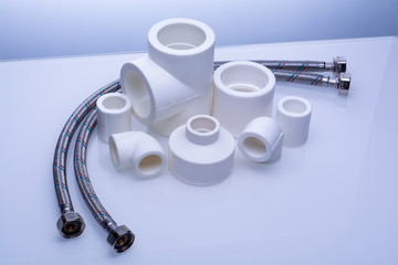 set of fittings for PVC pipes and reinforced water hose on a white background