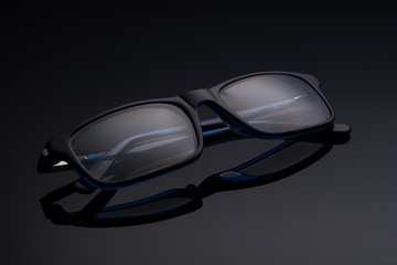 blue black spectacles on black glass