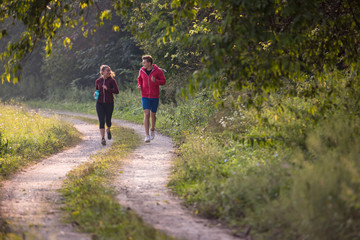 Obraz premium young couple jogging along a country road