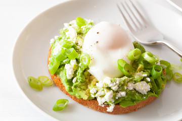 breakfast avocado sandwich with poached egg and feta cheese