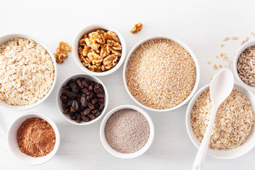 variaty of raw cereals and nuts for breakfast. Oatmeal flakes and steel cut, barley, walnut, chia, raisins. Healthy ingredients